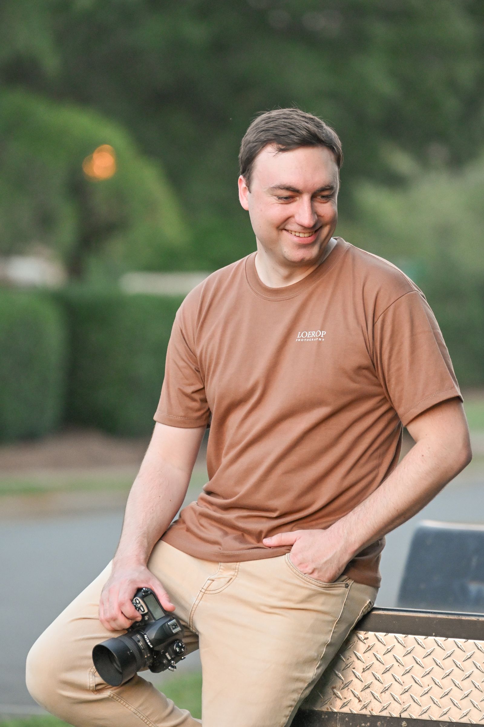 Mike Loerop seated on a trailer with his camera in hand