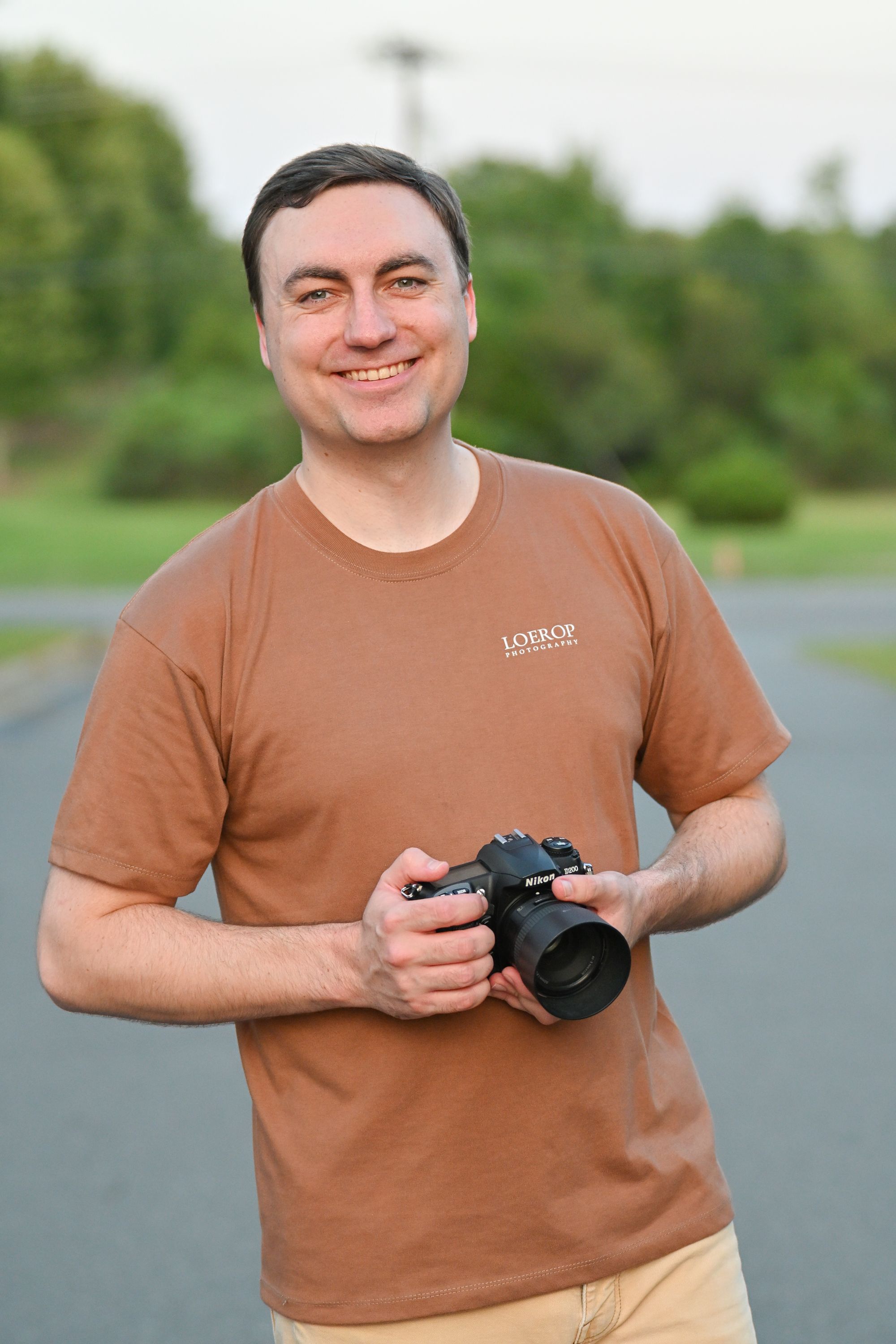 Mike Loerop holding his camera outdoors