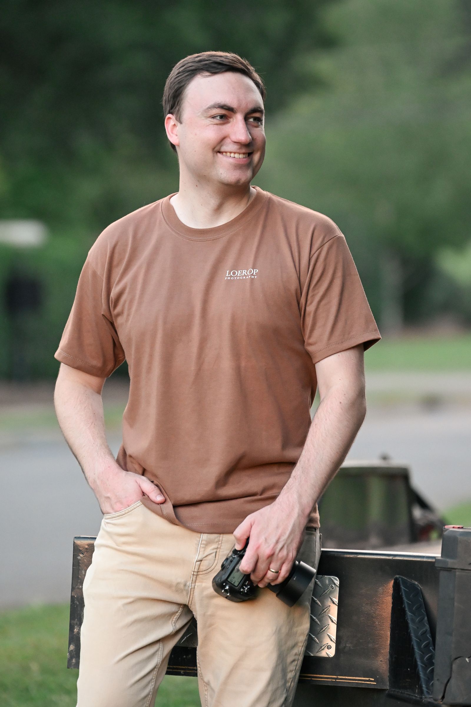 Mike Loerop standing outdoors on a summer evening, camera in hand