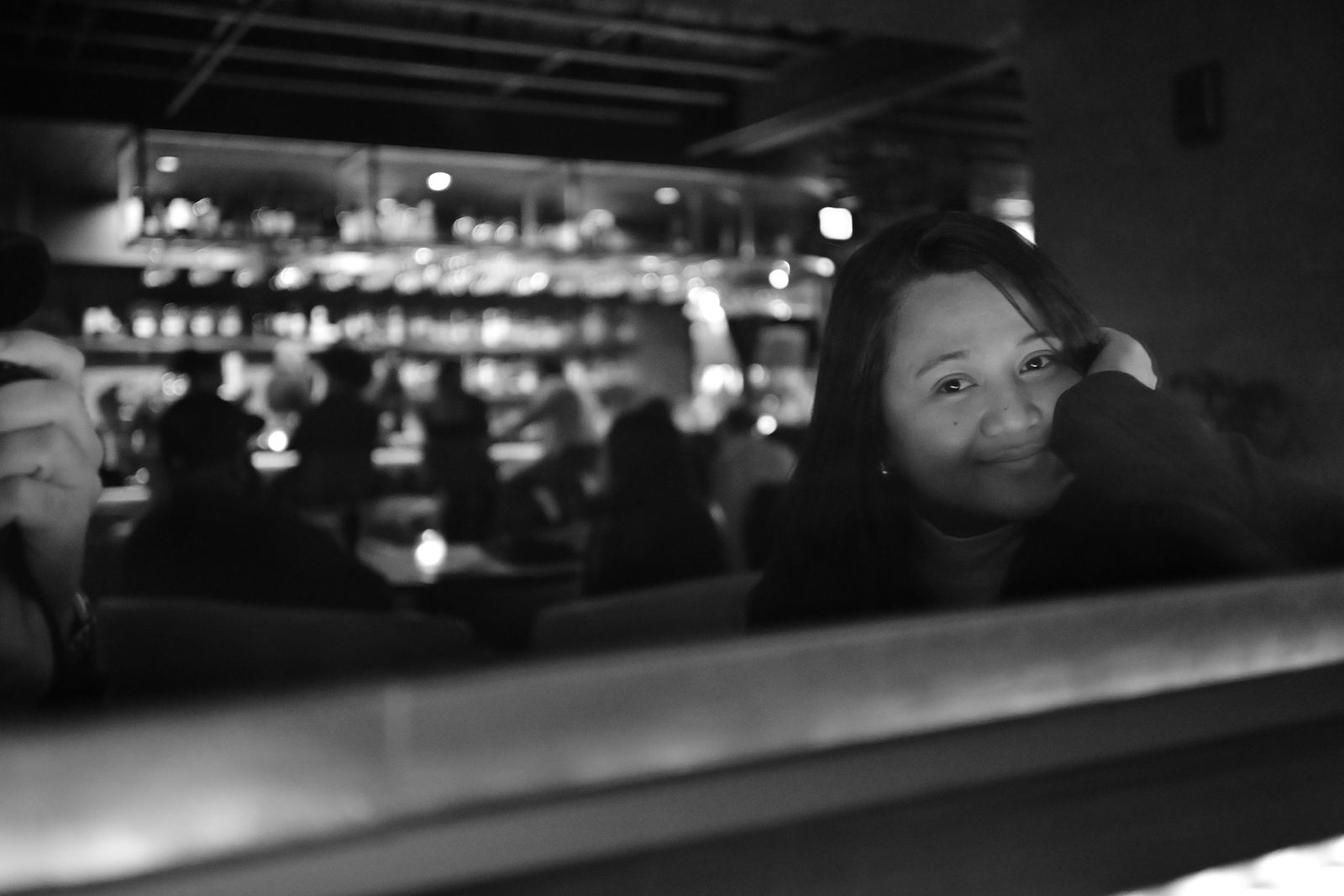 Black and white portrait of Winnie, Mike Loerop’s wife, smiling in a restaurant booth, photographed by Mike Loerop